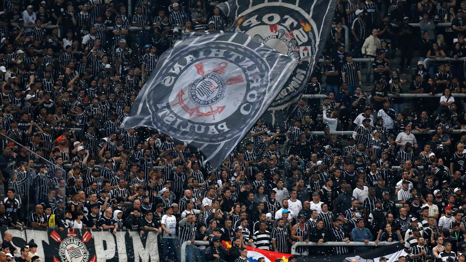 Torcida do Corinthians com bandeiras no estádio
